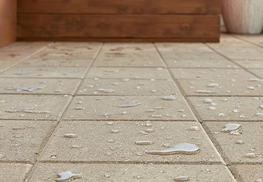 Concrete patio pavers with beading water that proves Thompson’s WaterSeal Clear Multi-Surface Waterproofer is on the job