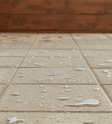 Concrete patio pavers with beading water that proves Thompson’s WaterSeal Clear Multi-Surface Waterproofer is on the job