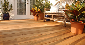 Lightly toned deck with deck furniture and plants. 